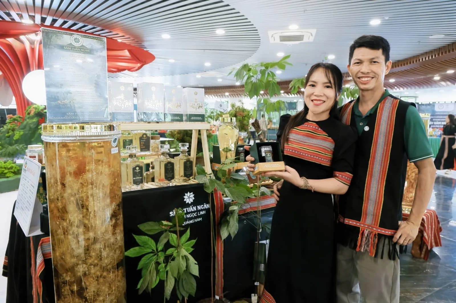 Hai thành viên Sâm Tuấn Ngân mặc trang phục thổ cẩm tại gian hàng ở lễ hội sâm
